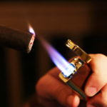 brown and gold cigar lighter in use